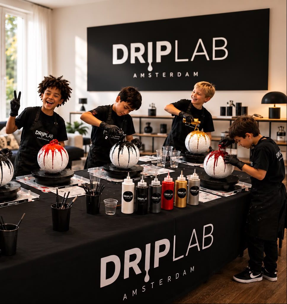 Kinderen maken drip art helmen tijdens een DRIPLAB workshop in Amsterdam, met het DRIPLAB Amsterdam logo op de achtergrond